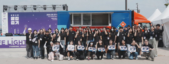 도미노피자 임직원들이 지난 7일 서울 여의도 한강공원에서 '생명사랑 밤길걷기' 행사에 참여해 기념촬영을 하고 있다. 도미노피자 제공